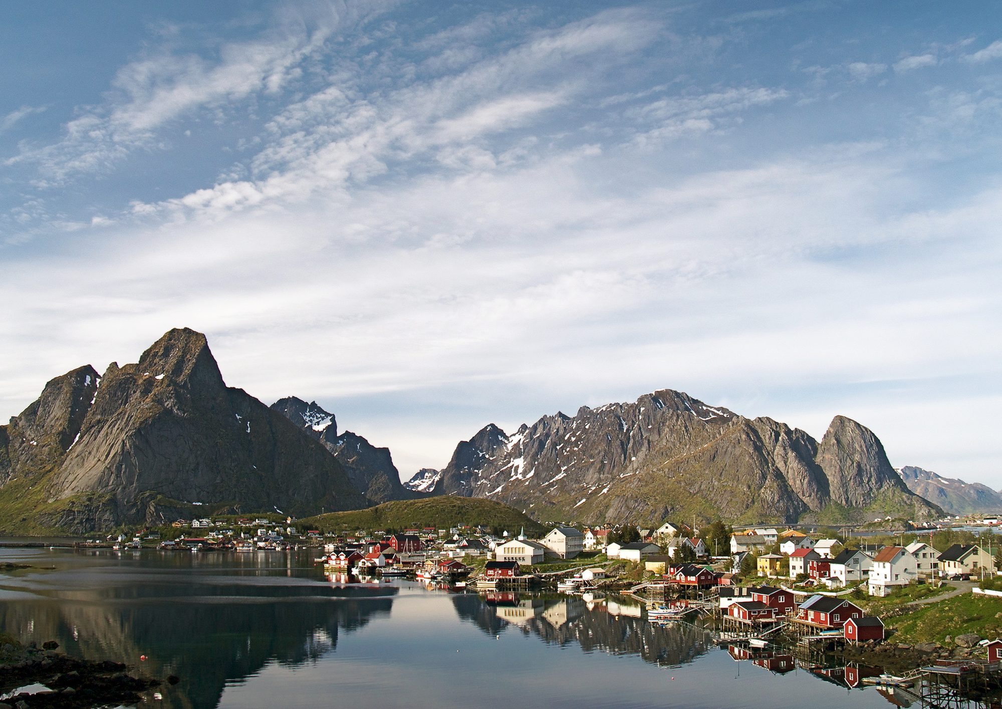 The fishing village of Reine in Lofoten, mountains mirrored in still water